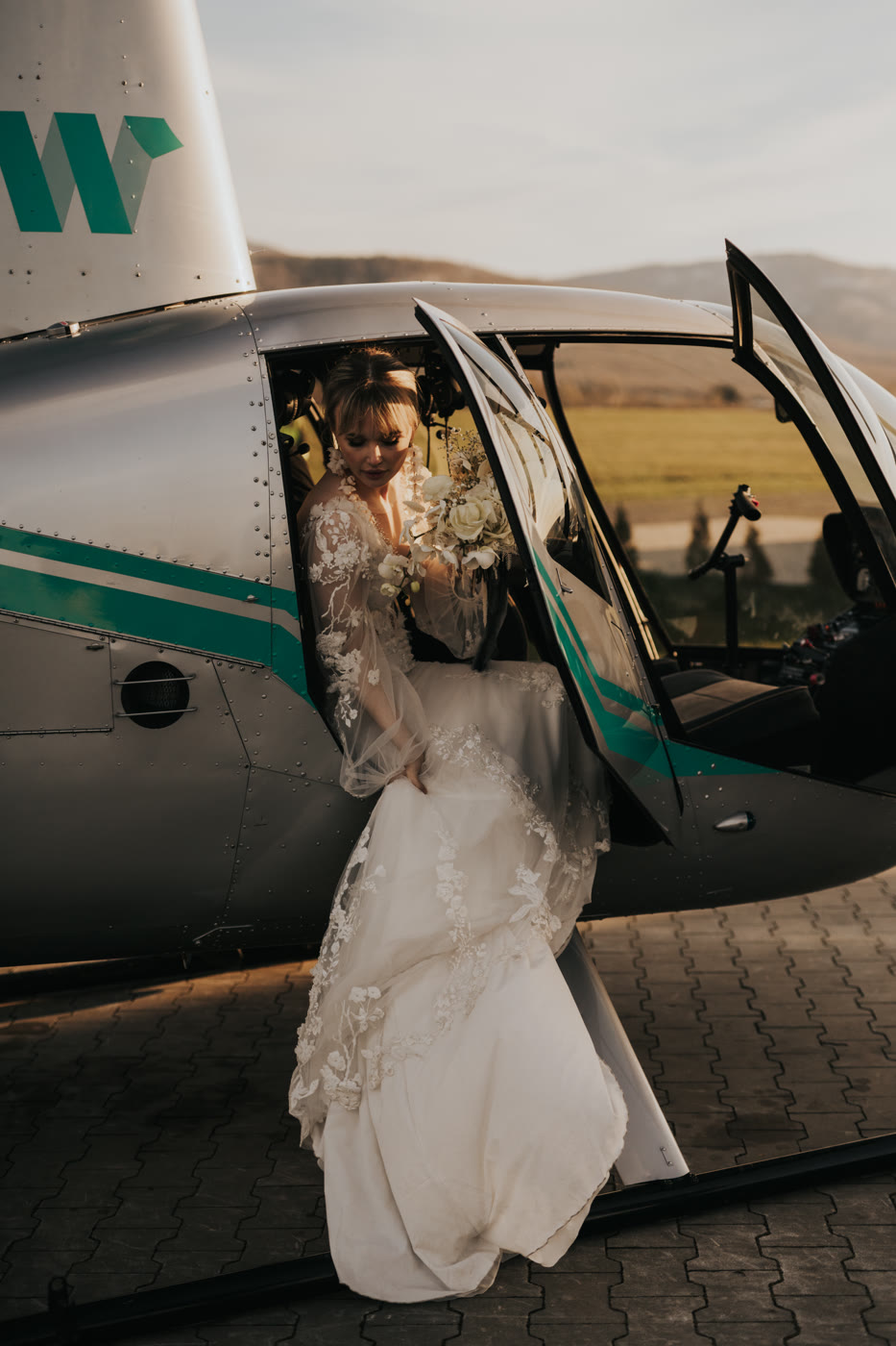 Panna Młoda w drzwiach helikoptera, elegancka sesja ślubna